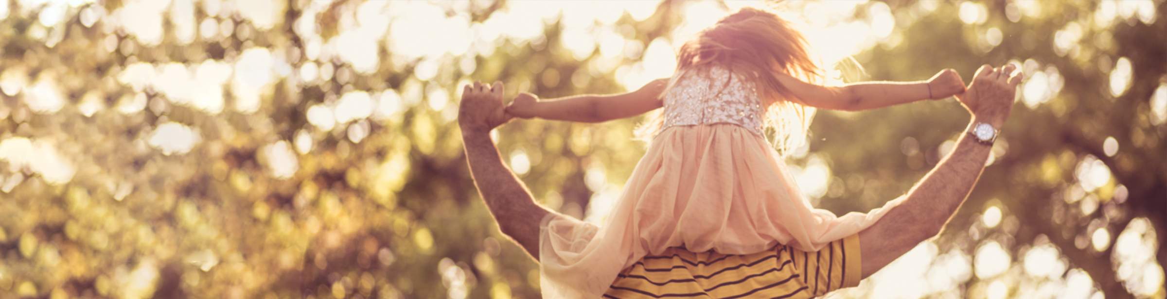 a daughter sitting on her father's shoulders